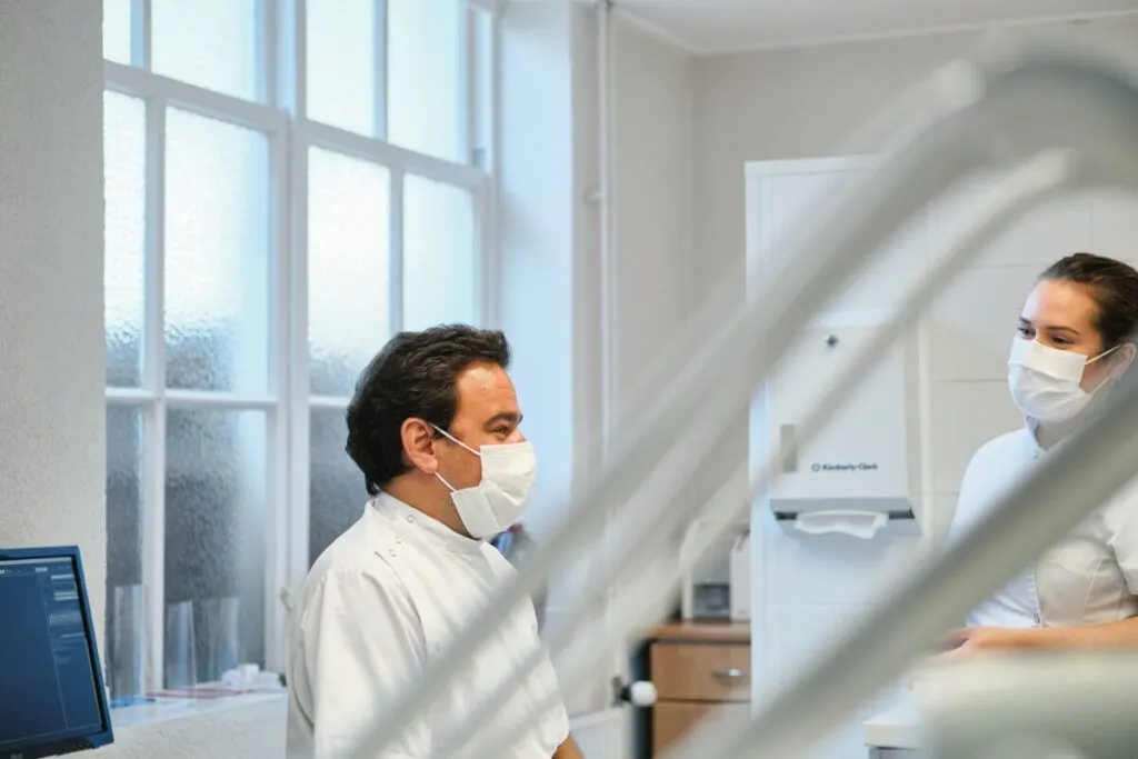 Tandarts en assistente in een lichte behandelkamer